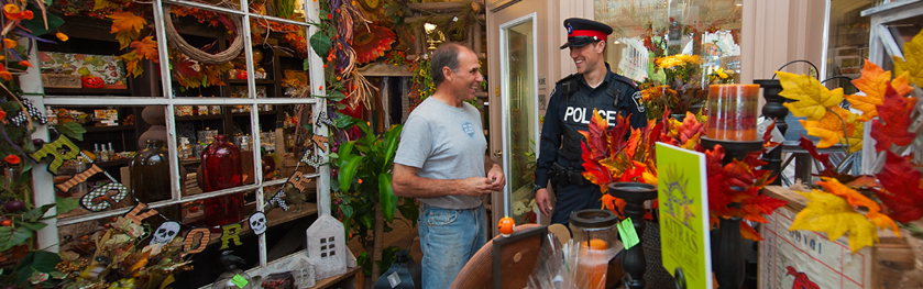 An officer and man stand in a decorated shop